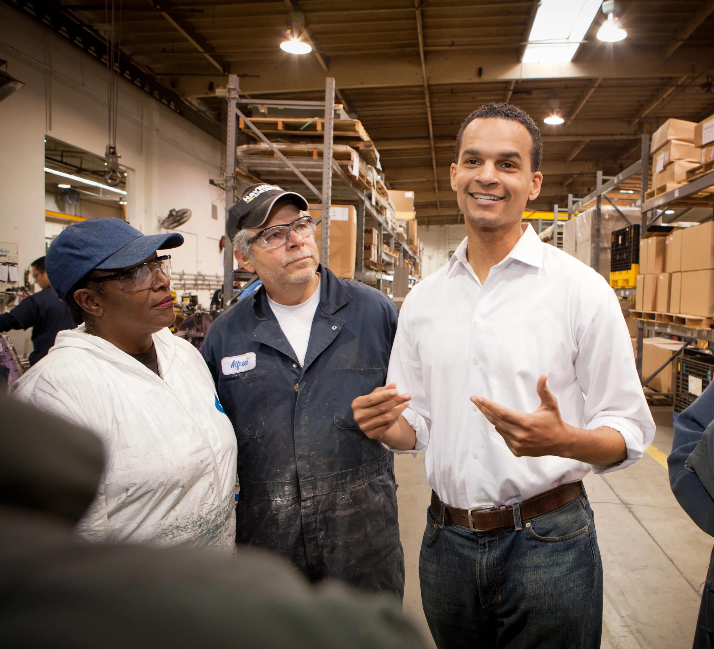 Joel Young talking with workers on a warehouse floor